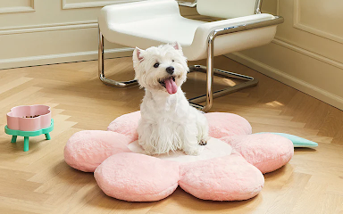 a puppy sitting on a flower shaped dog bed